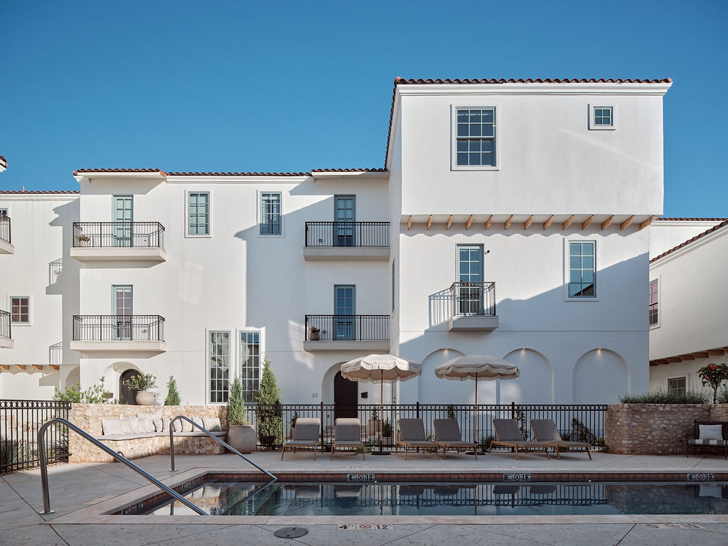 a large white building with a pool of water in front of it