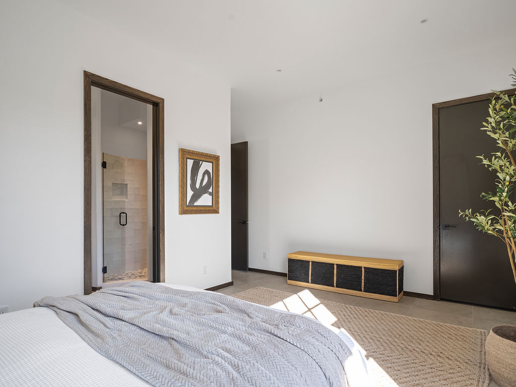 a bedroom with a large bed and a large mirror